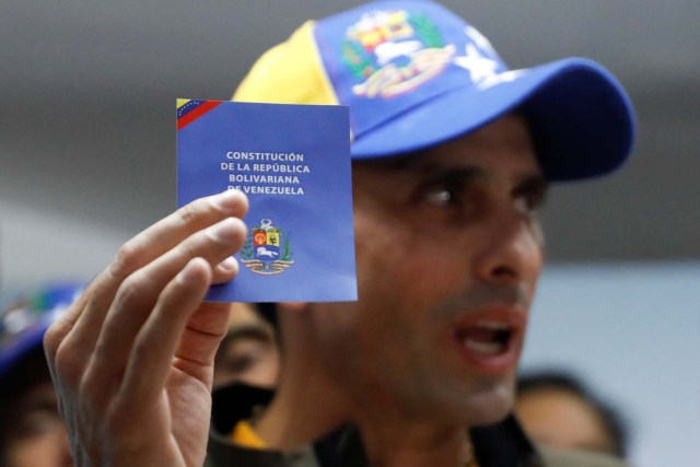 Venezuelan opposition leader and Governor of Miranda state Henrique Capriles holds a copy of the Venezuelan Constitution as he speaks during a news conference in Caracas, Venezuela April 6, 2017. REUTERS/Carlos Garcia Rawlins