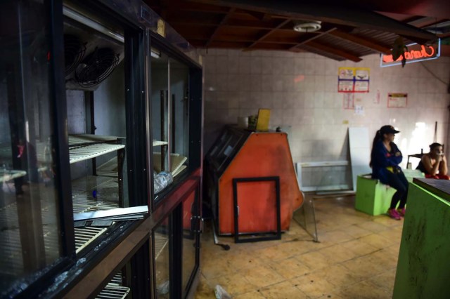 Picture taken on April 20, 2017 showing the damages casued by looters in a business in Caracas a day after demonstrations pro and against the government of Venezuelan President Nicolas Maduro. Venezuelan riot police fired tear gas Thursday at groups of protesters seeking to oust Maduro, who have vowed new mass marches after a day of deadly unrest. On the eve, hundreds of thousands of people fed up with food shortages and demanding elections joined protest marches in Caracas and several other cities while thousands of Maduro's supporters held a counter-rally in central Caracas.  / AFP PHOTO / Ronaldo SCHEMIDT