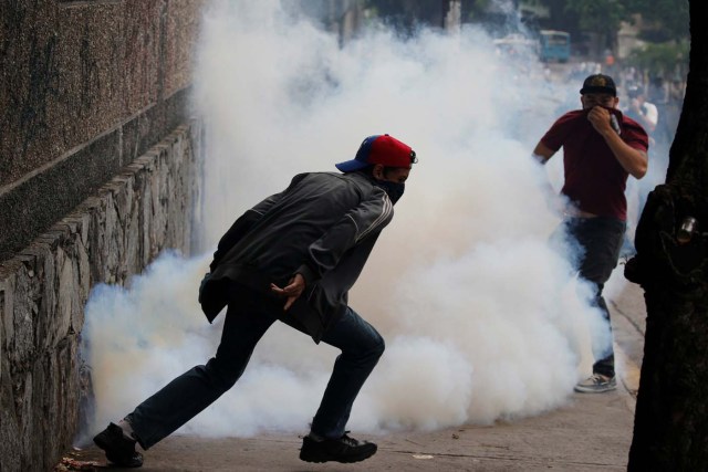 Demonstrators run away from tear gas during a protest against Venezuela's President Nicolas Maduro's government in Caracas, Venezuela May 2, 2017. REUTERS/Carlos Garcia Rawlins