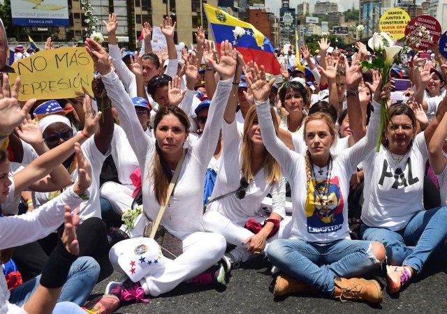 The wife of imprisoned opposition leader Leopoldo Lopez, Lilian Tintori (2nd R), takes part in a women's march aimed to keep pressure on President Nicolas Maduro, whose authority is being increasingly challenged by protests and deadly unrest, in Caracas on May 6, 2017. The death toll since April, when the protests intensified after Maduro's administration and the courts stepped up efforts to undermine the opposition, is at least 36 according to prosecutors. / AFP PHOTO / RONALDO SCHEMIDT