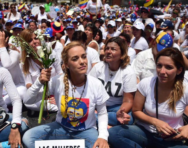The wife of imprisoned opposition leader Leopoldo Lopez, Lilian Tintori (L), takes part in a women's march aimed to keep pressure on President Nicolas Maduro, whose authority is being increasingly challenged by protests and deadly unrest, in Caracas on May 6, 2017. The death toll since April, when the protests intensified after Maduro's administration and the courts stepped up efforts to undermine the opposition, is at least 36 according to prosecutors. / AFP PHOTO / RONALDO SCHEMIDT
