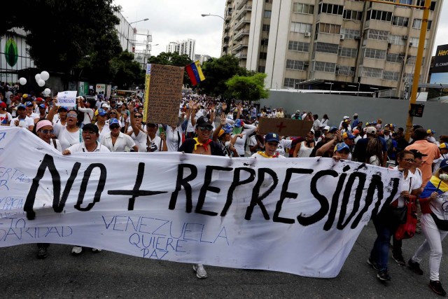Demonstrators hold a banner that reads "No more repression" during a women's march to protest against President Nicolas Maduro's government in Caracas, Venezuela, May 6, 2017. REUTERS/Carlos Garcia Rawlins