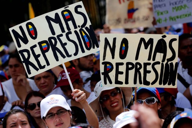 Demonstrators hold placards that read "No more repression" during a women's march to protest against President Nicolas Maduro's government in Caracas, Venezuela, May 6, 2017. REUTERS/Carlos Garcia Rawlins