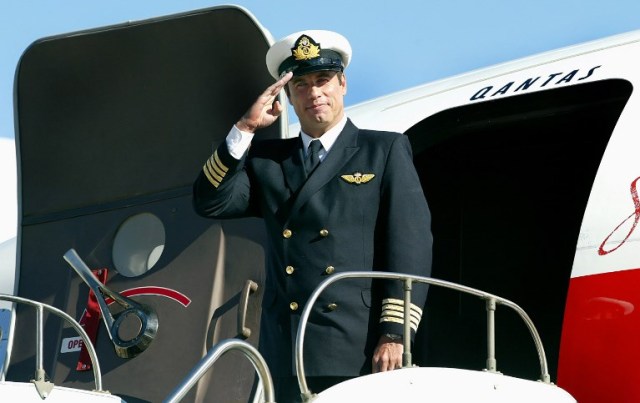 (FILES) A file photo taken on July 12, 2002, shows Hollywood star and Qantas "Ambassador-at-Large" John Travolta, standing in front of his Boeing 707 at Sydney Airport. Travolta has donated his "beloved" Boeing 707 plane to an Australian aviation museum and is aiming to be part of the crew to deliver the vintage aircraft down under. Made for Qantas Airways in 1964, Travolta acquired the Boeing 707 long after Australia's national carrier retired the jet. / AFP PHOTO / Greg Wood