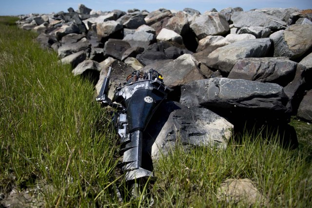 An abandoned outboard boat motor sits against the man-made sea wall that was engineered by the Army Corps of Engineers in 1999 to prevent erosion in Tangier, Virginia, May 15, 2017, where climate change and rising sea levels threaten the inhabitants of the slowly sinking island. Now measuring 1.2 square miles, Tangier Island has lost two-thirds of its landmass since 1850. If nothing is done to stop the erosion, it may disappear completely in the next 40 years. / AFP PHOTO / JIM WATSON