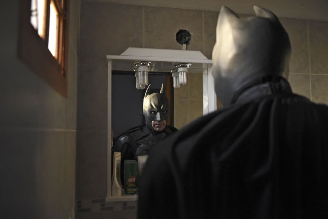 Argentine Batman, looks at his reflexion in a mirror after leaving his house in La Plata, 60 kilometres south of Buenos Aires, on June 2, 2017.  The Argentine Batman has made La Plata children's hospital a target of laughter and treats against pain. / AFP PHOTO / Eitan ABRAMOVICH