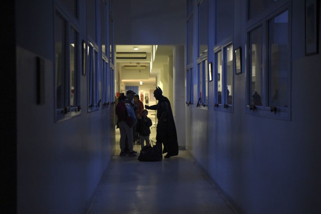 Argentine Batman, greets a family in a corridor of the 'Sor Maria Ludovica' children's Hospital in La Plata, 60 kilometres south of Buenos Aires, on June 2, 2017.  The Argentine Batman has made La Plata children's hospital a target of laughter and treats against pain. / AFP PHOTO / Eitan ABRAMOVICH