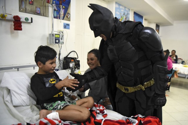 Pablo Valdez (L), 7, who is hospitalized with an infection that prevents him fom walking, is cheered up by Argentine Batman at the 'Sor Maria Ludovica' children's Hospital in La Plata, 60 kilometres south of Buenos Aires, on June 2, 2017.  The Argentine Batman has made La Plata children's hospital a target of laughter and treats against pain. / AFP PHOTO / Eitan ABRAMOVICH / TO GO WITH AFP STORY BY PAULA BUSTAMANTE MORE PICTURES IN AFPFORUM