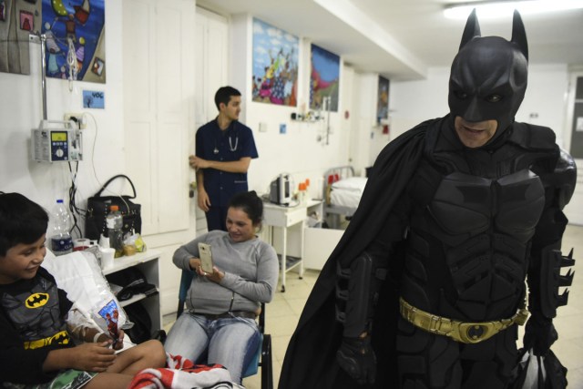 Pablo Valdez (L), 7, who is hospitalized with an infection that prevents him fom walking, is cheered up by Argentine Batman at the 'Sor Maria Ludovica' children's Hospital in La Plata, 60 kilometres south of Buenos Aires, on June 2, 2017.  The Argentine Batman has made La Plata children's hospital a target of laughter and treats against pain. / AFP PHOTO / Eitan ABRAMOVICH