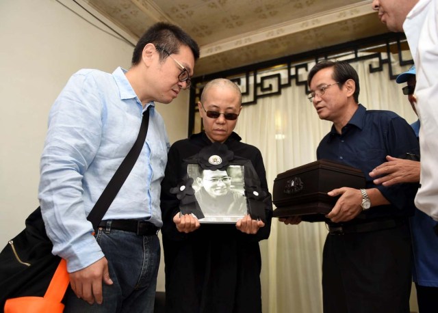 Liu Xia, wife of deceased Chinese Nobel Peace Prize-winning dissident Liu Xiaobo, holds his picture during his funeral in Shenyang, China in this photo released by Shenyang Municipal Information Office on July 15, 2017. Shenyang Municipal Information Office/via REUTERS. ATTENTION EDITORS - THIS IMAGE WAS PROVIDED BY A THIRD PARTY. NO RESALES. NO ARCHIVES. TPX IMAGES OF THE DAY
