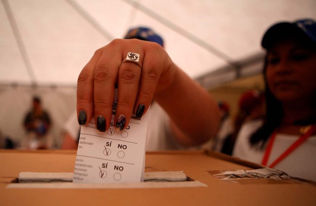 A woman casts her vote during an unofficial plebiscite against President Nicolas Maduro's government, in Bogota, Colombia July 16, 2017.  REUTERS/Jaime Saldarriaga