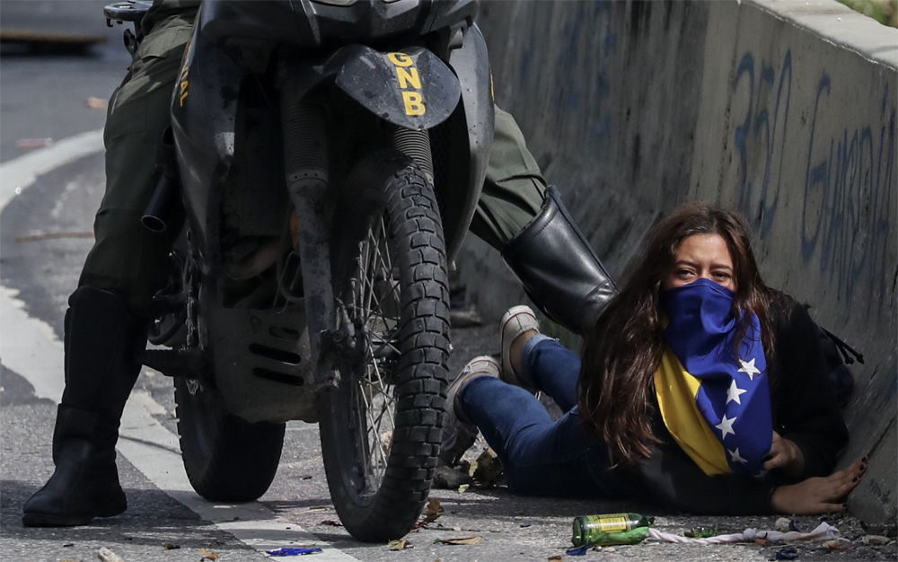 Cobardía con sello Nicolás: Un GNB en moto pateando por la espalda a una mujer en el suelo (FOTO)
