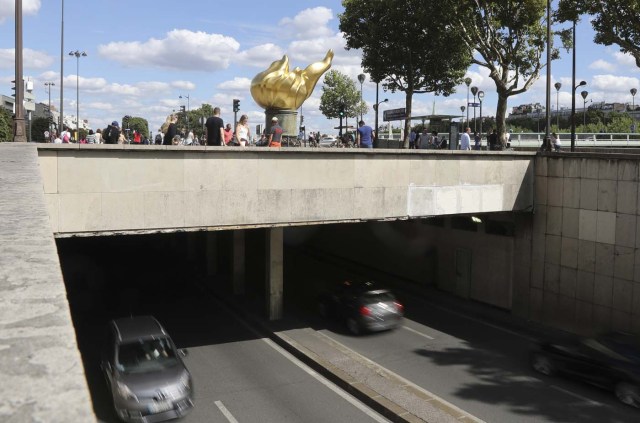 People walk around the "Flamme de la Liberté" (Liberty Flame), an original monument Princess Diana fans turned into a commemoration stele, in Paris on august 14, 2017. 20th anniversary of the death of Princess Diana in a Paris car crash will be marked on August 31, 2017. / AFP PHOTO / JACQUES DEMARTHON