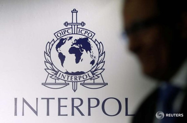 Foto de archivo. Un hombre pasa frente a un logotipo de Interpol durante la ceremonia de entrega de los nuevos locales para el Complejo Global para la Innovación de Interpol, en Singapur 30 de septiembre de 2014. REUTERS/Edgar Su/File Photo - RTSIHYZ
