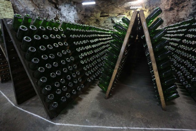A picture taken on July 12, 2017 shows bottles of wine in the "Artwinery" winery firm in the eastern Ukrainian city of Bakhmut. The winery is located in a government-held town just two dozen kilometres (15 miles) from the frontline in Ukraine's low-level war, where the army and Russian-backed rebels continue to lob deadly artillery barrages at each other. The town spent around a month under rebel control in 2014, and in 2015 the frontline was so close that the town came under rebel shelling. But despite more than three years of fighting that has claimed some 10,000 lives, Nasyrov's employer, Artwinery, has never stopped production. / AFP PHOTO / Aleksey FILIPPOV