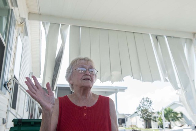 Stasia Walsh speaks in front of her partially damaged home at the Enchanted Shores manufactured home park in Naples, Florida, on September 11, 2017 after Hurricane Irma hit Florida. Walsh and her family rode out the storm in their home. / AFP PHOTO / NICHOLAS KAMM