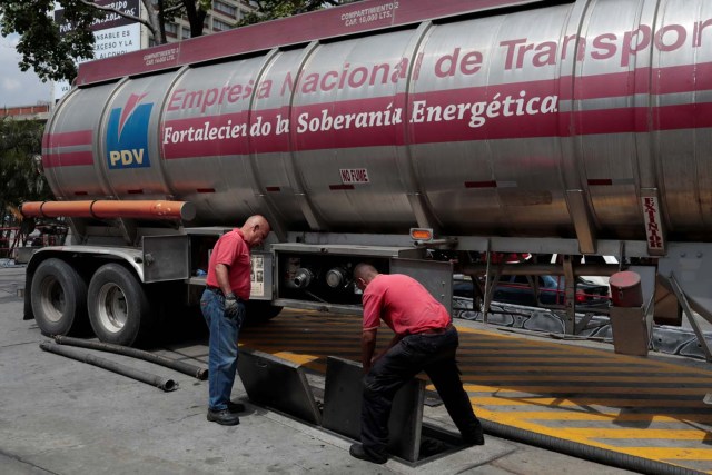 Workers set up a fuel tank truck for unloading gasoline at a gas station of Venezuelan state-owned oil company PDVSA in Caracas, Venezuela September 21, 2017. REUTERS/Marco Bello