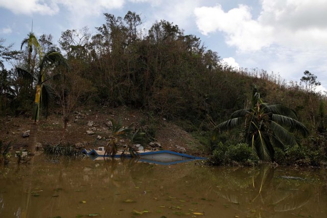 The roof of a house submerged by flood waters is seen close to the dam of the Guajataca lake after the area was hit by Hurricane Maria in Guajataca, Puerto Rico September 23, 2017. REUTERS/Carlos Garcia Rawlins