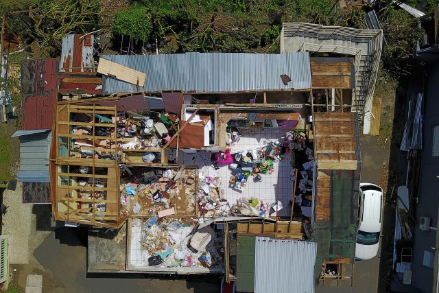 A house destroyed by hurricane winds is seen in Toa Alta, southwest of San Juan, Puerto Rico, on September 24, 2017 following the passage of Hurricane Maria. Authorities in Puerto Rico rushed on September 23, 2017 to evacuate people living downriver from a dam said to be in danger of collapsing because of flooding from Hurricane Maria. / AFP PHOTO / Ricardo ARDUENGO