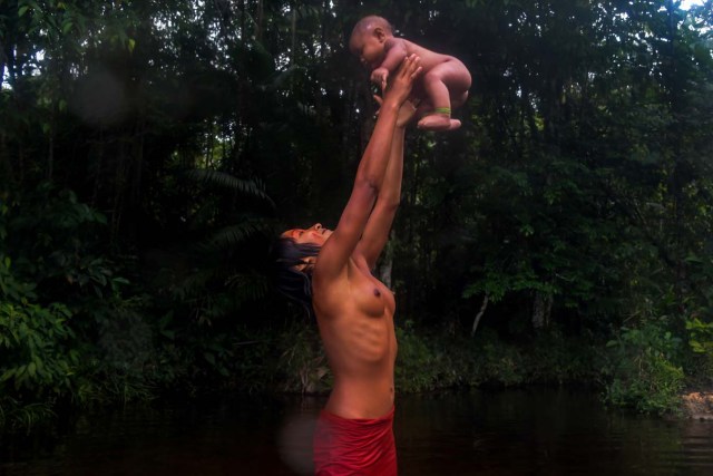 Meri Waiapi bathes with her cousin at the Feliz river in the Waiapi indigenous reserve in Amapa state in Brazil on October 14, 2017.  Tribal chieftain Tzako Waiapi perfectly remembers the day almost half a century ago when his hunting party stumbled across a group of white adventurers in the Amazon rainforest. Within months, nearly everyone in his entire tribe had died from disease.  / AFP PHOTO / Apu Gomes / TO GO WITH AFP STORY "When the Waipai tribe almost died out" by Sebastian Smith