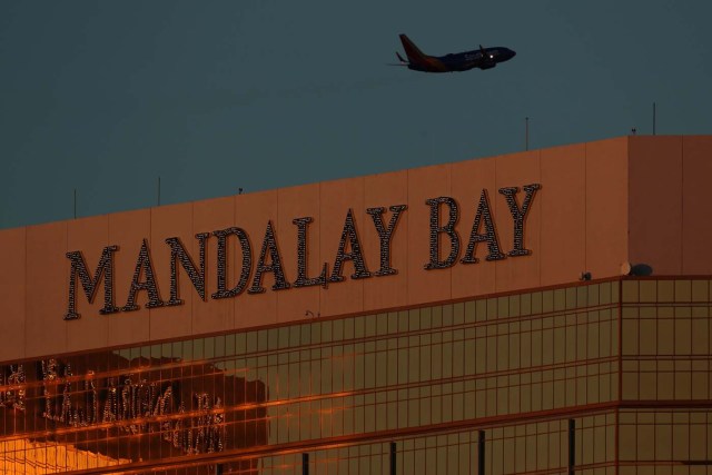 A departing passenger plane flies over the Mandalay Bay hotel in Las Vegas, Nevada, U.S., October 3, 2017. REUTERS/Mike Blake