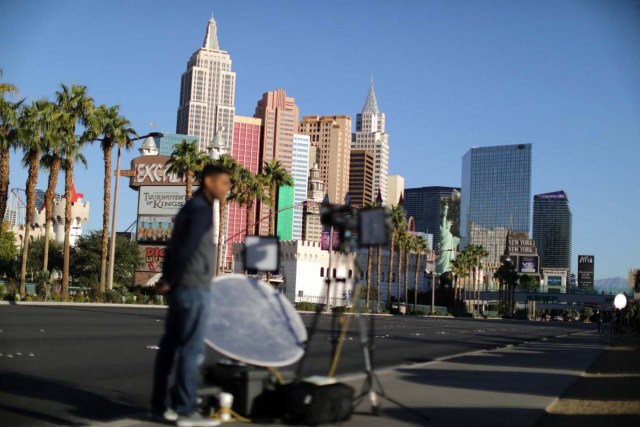 Member of a news crew stands in front of the closed Las Vegas Strip next to the site of the Route 91 music festival mass shooting outside the Mandalay Bay Resort and Casino in Las Vegas, Nevada, U.S., October 3, 2017. REUTERS/Lucy Nicholson