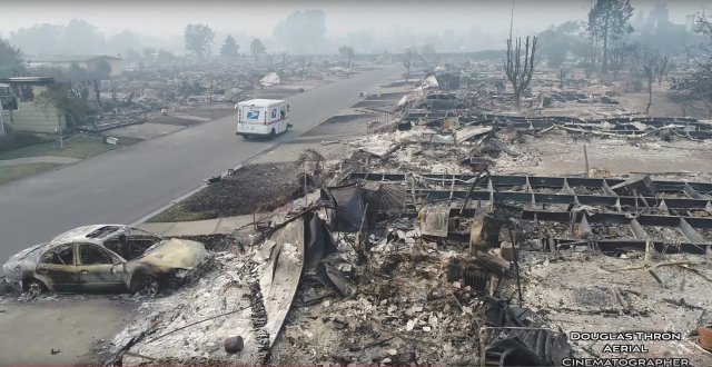 A postman delivers mail in fire-devastated Santa Rosa, California, United States October 10, 2017 is seen in this still images obtained from social media video. Douglas Thron/ via REUTERS  THIS IMAGE HAS BEEN SUPPLIED BY A THIRD PARTY. MANDATORY CREDIT. NO RESALES. NO ARCHIVES. MUST ON SCREEN COURTESY NAOTO YOSHIDOME  MUST NOT OBSCURE DOUGLAS THRON LOGO