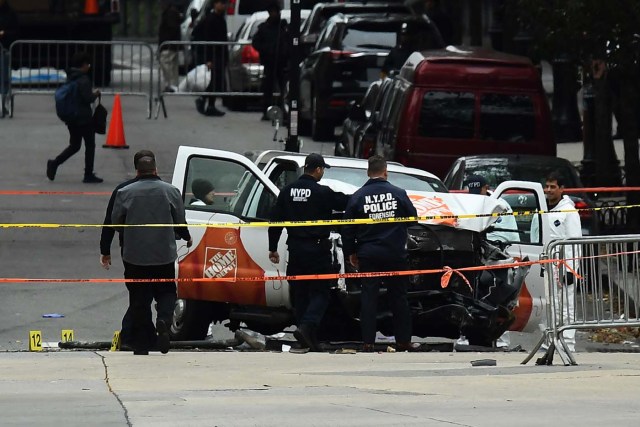Investigators work around the wreckage of a Home Depot pickup truck, a day after it was used in an terror attack, in New York on November 1, 2017. The pickup truck driver who plowed down a New York cycle path, killing eight people, in the city's worst attack since September 11, was associated with the Islamic State group but "radicalized domestically," the state's governor said Wednesday. The driver, identified as Uzbek national named Sayfullo Saipov was shot by police in the stomach at the end of the rampage, but he was expected to survive. / AFP PHOTO / Jewel SAMAD