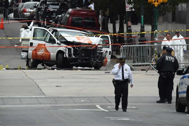 Investigators work around the wreckage of a Home Depot pickup truck a day after it was used in a terror attack in New York on November 1, 2017. The pickup truck driver who plowed down a New York cycle path, killing eight people, in the city's worst attack since September 11, was associated with the Islamic State group but "radicalized domestically," the state's governor said Wednesday. The driver, identified as Uzbek national named Sayfullo Saipov was shot by police in the stomach at the end of the rampage, but he was expected to survive. / AFP PHOTO / Jewel SAMAD