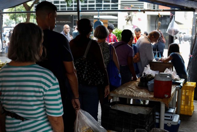 People line up to pay for their fruits and vegetables at a street market in Caracas, Venezuela November 3, 2017. Picture taken November 3, 2017. REUTERS/Marco Bello