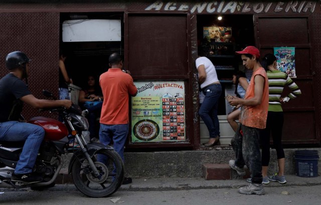 People wager money on "Los Animalitos" (or the Little Animals) betting game on the outskirts of Caracas, Venezuela, October 9, 2017. REUTERS/Ricardo Moraes SEARCH "MORAES GAMBLING" FOR THIS STORY. SEARCH "WIDER IMAGE" FOR ALL STORIES.