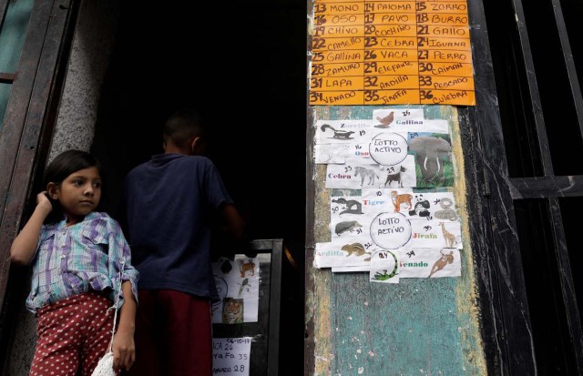 A child wagers money on "Los Animalitos" (or the Little Animals) betting game on the outskirts of Caracas, Venezuela, October 6, 2017. REUTERS/Ricardo Moraes SEARCH "MORAES GAMBLING" FOR THIS STORY. SEARCH "WIDER IMAGE" FOR ALL STORIES.