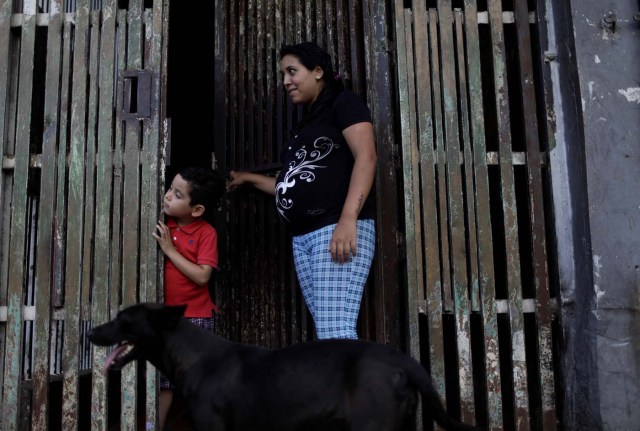 Natalie Torres, 24, stands with her child, Abel, at the entrance to their building after betting money on "Los Animalitos" (or the Little Animals) betting game on the outskirts of Caracas, Venezuela, October 11, 2017. The last time Torres won a prize on the "Los Animalitos" she bought school supplies for Abel. REUTERS/Ricardo Moraes SEARCH "MORAES GAMBLING" FOR THIS STORY. SEARCH "WIDER IMAGE" FOR ALL STORIES.