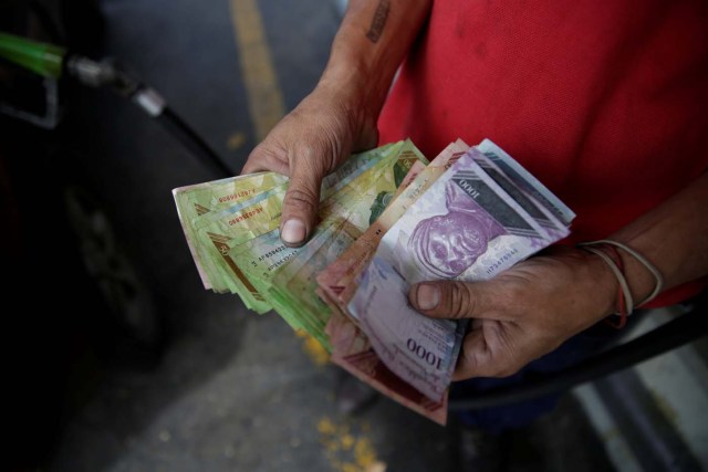  Un trabajador cuenta bolívares venezolanos en una gasolinera de la petrolera estatal venezolana PDVSA en Caracas, Venezuela, el 1 de diciembre de 2017. REUTERS / Marco Bello