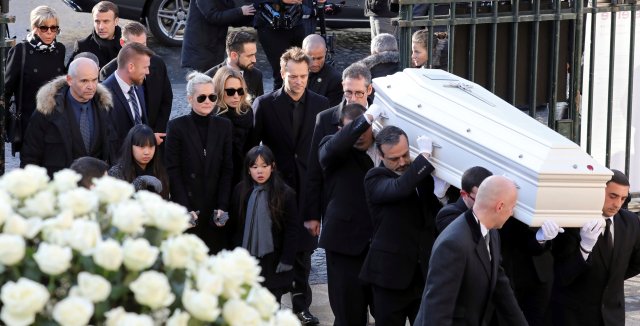 The wife of late French singer Johnny Hallyday, Laeticia (3rdL), his daughter Laura Smet (4thL), his son David Hallyday (5thL, C), his daughters Joy (Bottom R) and Jade (Bottom L), French President Emmanuel Macron (Top, 2ndR) and his wife Brigitte walk with the coffin outside at the Madeleine Church at the start of the funeral ceremony in Paris, France, December 9, 2017. REUTERS/Ludovic Marin/Pool