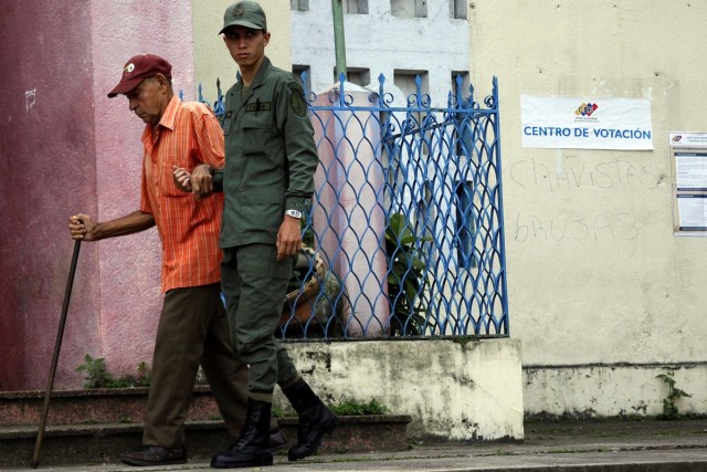 A soldier helps a man outside a polling station during a nationwide election for new mayors, in Rubio, Venezuela December 10, 2017. REUTERS/Carlos Eduardo Ramirez