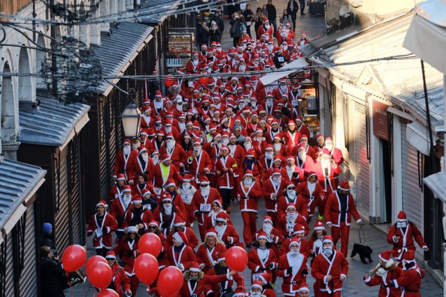 People dressed as Santa Claus run during a Christmas race in Venice, Italy December 17, 2017. REUTERS/Manuel Silvestri