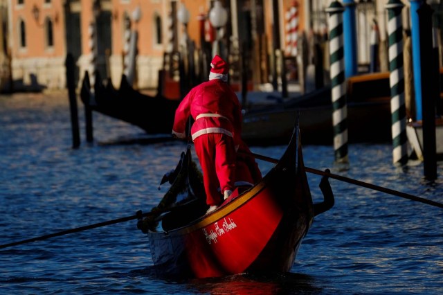 A man dressed as Santa Claus rows during a Christmas regatta in Venice, Italy December 17, 2017. REUTERS/Manuel Silvestri