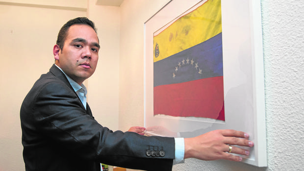 Carlos Moreno, frente a la bandera venezolana con restos de la sangre de su hermano Paúl - Belén Díaz