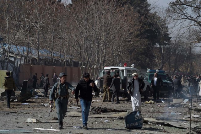Afghan volunteers and policemen carry injured men on an ambulance at the scene of a car bomb exploded in front of the old Ministry of Interior building in Kabul on January 27, 2018. An ambulance packed with explosives blew up in a crowded area of Kabul on January 27, killing at least 17 people and wounding 110 others, officials said, in an attack claimed by the Taliban. / AFP PHOTO / WAKIL KOHSAR
