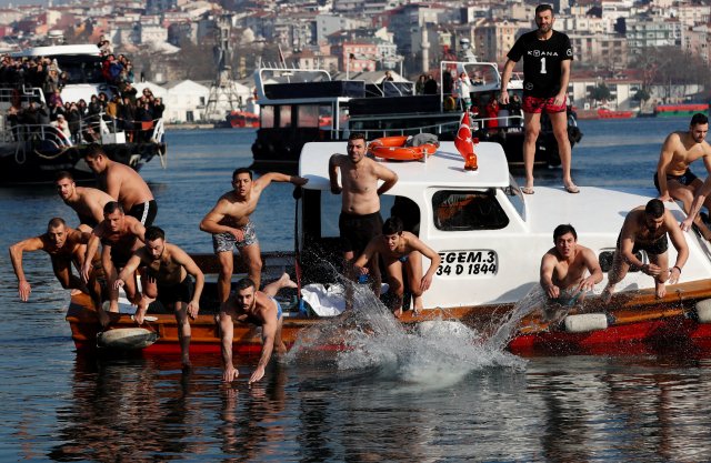 Greek Orthodox faithful swim towards a wooden crucifix in the Golden Horn in Istanbul, Turkey, January 6, 2018. REUTERS/Murad Sezer