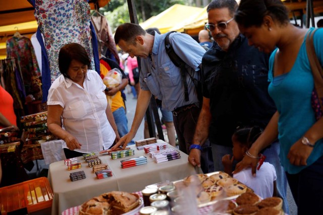 A customer looks at Mantuano chocolate bars on a street market in Caracas, Venezuela October 28, 2017. Picture taken October 28, 2017. REUTERS/Carlos Garcia Rawlins