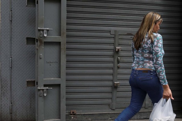 A woman walks past reinforced security gates at a store in downtown Caracas, Venezuela January 16, 2018. Picture taken January 16, 2018. REUTERS/Marco Bello