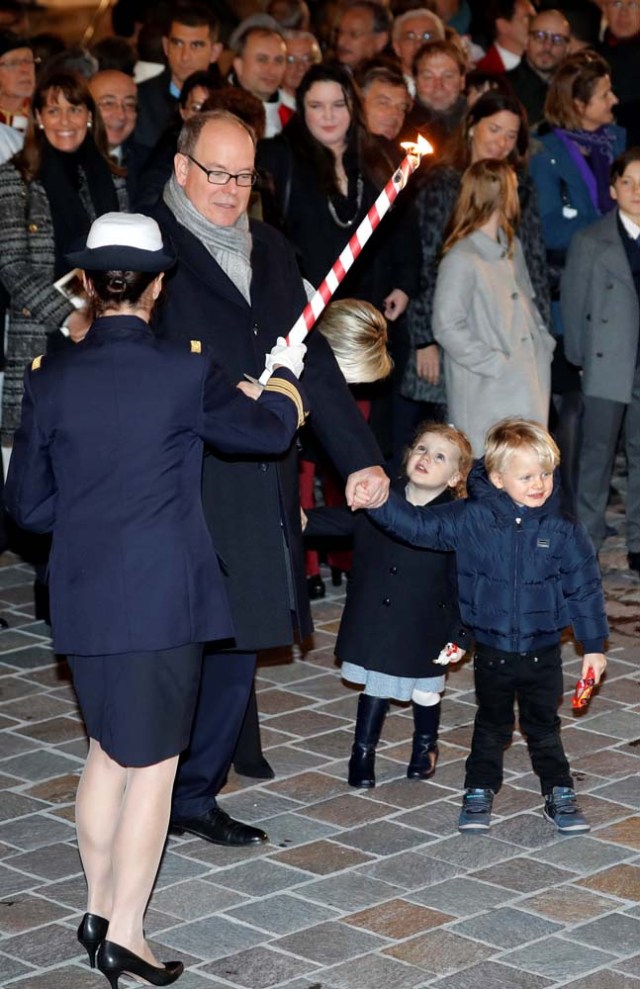 Prince Albert II of Monaco holds a torch to burn a small fisherman's boat as he attends the traditional Sainte Devote celebration with his twins Prince Jacques and Princess Gabriella in Monaco, January 26, 2018. REUTERS/Eric Gaillard