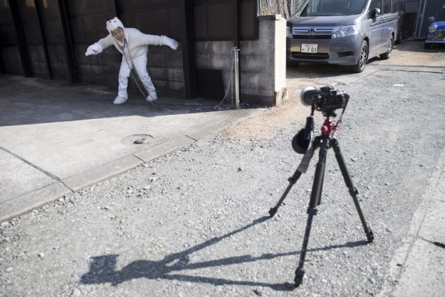 In this picture taken on January 16, 2018, Kimiko Nishimoto takes a self portrait during a photoshoot outside her house in the western Japanese city of Kumamoto. The madcap Japanese great-grandmother armed with a camera and an appetite for mischief has shot to fame for taking side-splitting selfies -- many of which appear to put her in harm's way. / AFP PHOTO / Behrouz MEHRI / TO GO WITH Japan-lifestyle-photography-offbeat-senior-citizens,FEATURE by Alistair HIMMER