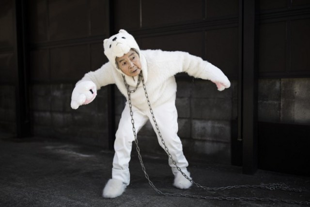 In this picture taken on January 16, 2018, Kimiko Nishimoto, dressed in a dog costume, gestures during a self photoshoot outside her house in the western Japanese city of Kumamoto. The madcap Japanese great-grandmother armed with a camera and an appetite for mischief has shot to fame for taking side-splitting selfies -- many of which appear to put her in harm's way. / AFP PHOTO / Behrouz MEHRI / TO GO WITH Japan-lifestyle-photography-offbeat-senior-citizens,FEATURE by Alistair HIMMER