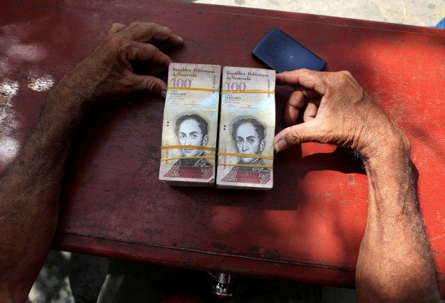 Un cambiador de dinero se sienta en una mesa en la frontera entre Colombia y Venezuela, en Paraguachon, Colombia 16 de febrero de 2018. Fotografía tomada el 16 de febrero de 2018. REUTERS / Jaime Saldarriaga