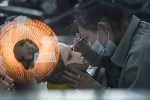 This photo taken on February 1, 2018 shows a worker painting the face of a silicone doll at a factory of EXDOLL, a firm based in the northeastern Chinese port city of Dalian. With China facing a massive gender gap and a greying population, a company wants to hook up lonely men and retirees with a new kind of companion: "Smart" sex dolls that can talk, play music and turn on dishwashers. / AFP PHOTO / FRED DUFOUR / TO GO WITH China-sex-lifestyle, FOCUS by Joanna CHIU
