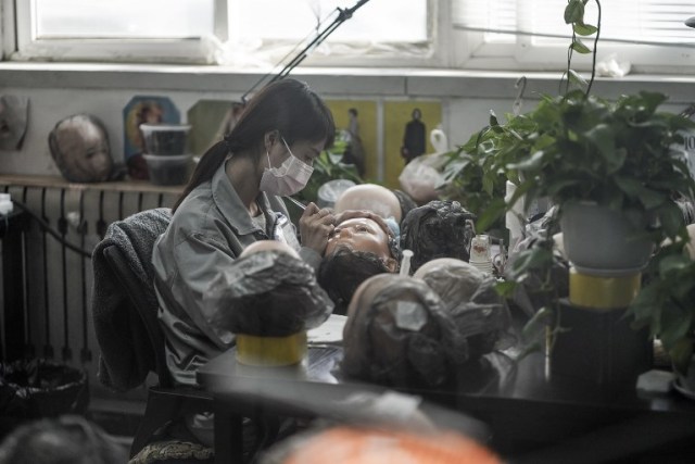 This photo taken on February 1, 2018 shows a worker painting the face of a silicone doll at a factory of EXDOLL, a firm based in the northeastern Chinese port city of Dalian. With China facing a massive gender gap and a greying population, a company wants to hook up lonely men and retirees with a new kind of companion: "Smart" sex dolls that can talk, play music and turn on dishwashers. / AFP PHOTO / FRED DUFOUR / TO GO WITH China-sex-lifestyle, FOCUS by Joanna CHIU