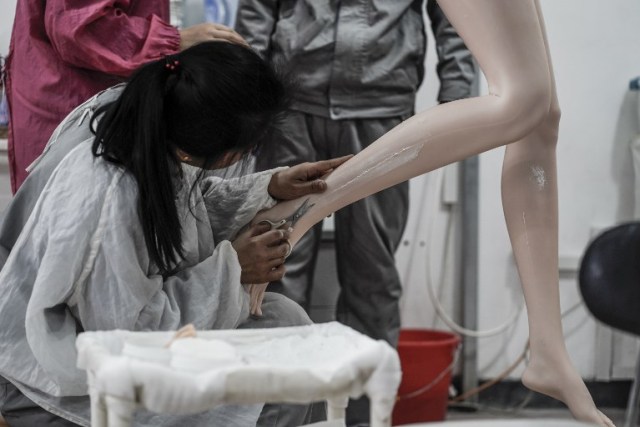 This photo taken on February 1, 2018 shows a worker trimming the skin imperfections of a silicone doll at a factory of EXDOLL, a firm based in the northeastern Chinese port city of Dalian. With China facing a massive gender gap and a greying population, a company wants to hook up lonely men and retirees with a new kind of companion: "Smart" sex dolls that can talk, play music and turn on dishwashers. / AFP PHOTO / FRED DUFOUR / TO GO WITH China-sex-lifestyle, FOCUS by Joanna CHIU